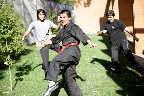 Un grupo de jóvenes practica artes marciales en un parque.