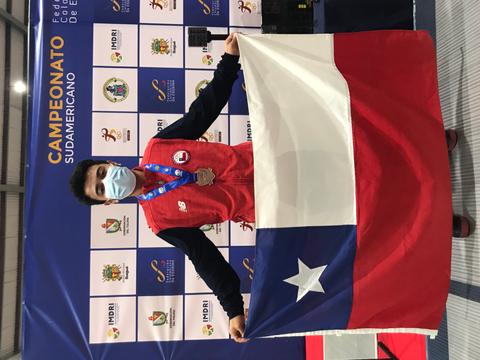 Un competidor orgulloso muestra la bandera de Chile y una medalla en un campeonato sudamericano.