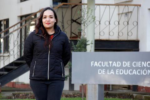 Una joven posa en la entrada de la Facultad de Ciencias de la Educación.
