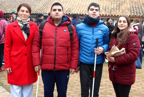 Un grupo de cuatro personas posando juntas en un entorno al aire libre.