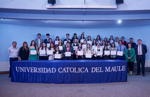 Un grupo de estudiantes posando con certificados en la Universidad Católica del Maule.