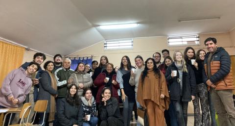 Un grupo de personas sonrientes posando en un aula.