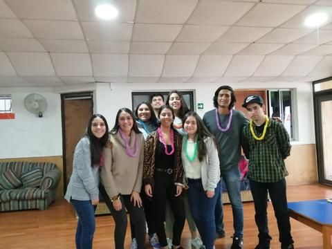 Un grupo de jóvenes sonrientes posando en una sala con decoración alegre.