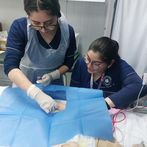 Dos estudiantes de medicina realizan una práctica en un entorno clínico.