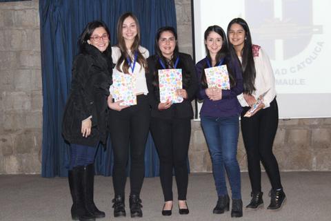 Un grupo de cinco mujeres posando juntas con diplomas o premios en un evento educativo.