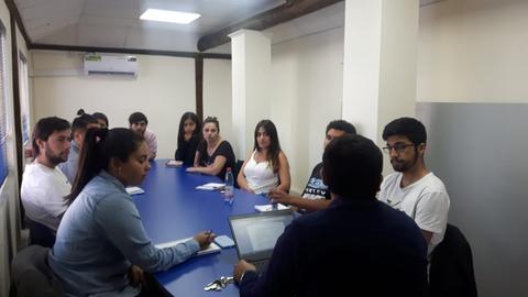 Una reunión de un grupo de personas sentadas alrededor de una mesa en una oficina.