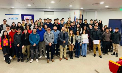 Un grupo de estudiantes posando juntos en un evento escolar, sosteniendo certificados.
