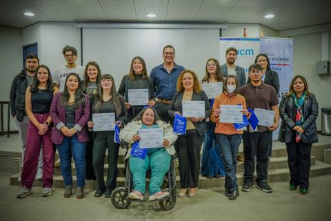 Grupo de personas sonriendo y mostrando sus certificados en un evento en Chile.