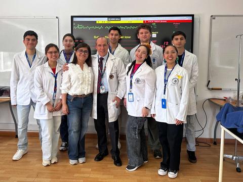 Un grupo de estudiantes de medicina posando juntos en una sala de clases.