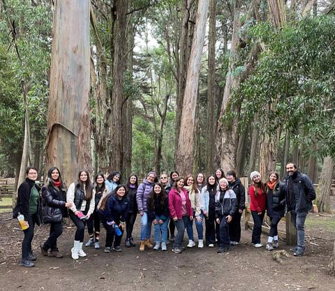 Grupo de personas sonriendo en un bosque de eucaliptos.