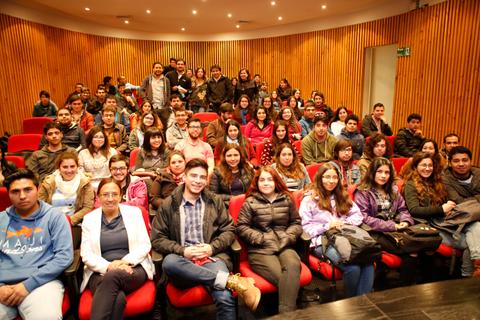 Un grupo grande de personas sentadas en un auditorio.
