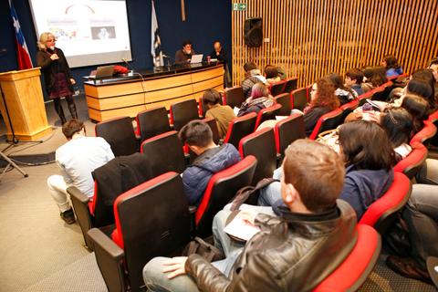 Una conferencia se está llevando a cabo en un auditorio con un público atento.