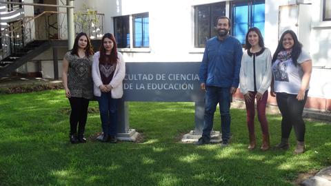 Grupo de personas posando frente a un cartel de la Facultad de Ciencia de la Educación.