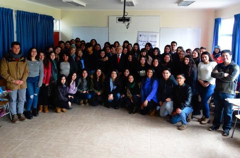 Un grupo numeroso de personas posando en un aula.