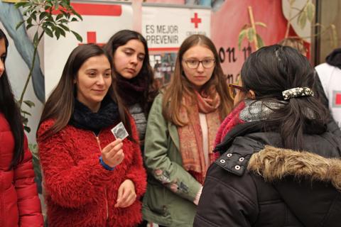 Un grupo de jóvenes interactúa en un evento relacionado con la Cruz Roja.