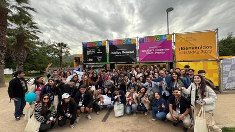 Un grupo grande de personas sonrientes reunidas en un evento al aire libre en Chile.