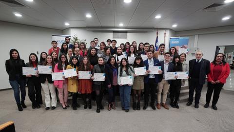 Un grupo de personas posando con diplomas en un evento de entrega de certificados.