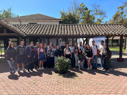 Grupo de personas sonrientes posando juntas en un entorno al aire libre.