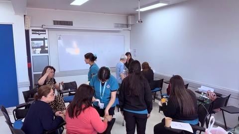 Un grupo de personas en un aula realizando actividades en equipo.