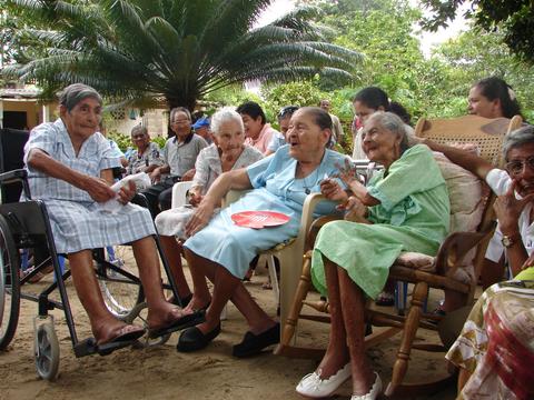 Un grupo de mujeres mayores sentadas y disfrutando de una conversación al aire libre.