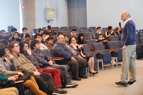 Un orador se dirige a un público juvenil en un auditorio.