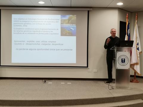 Un hombre presenta información sobre biodiversidad en una conferencia.