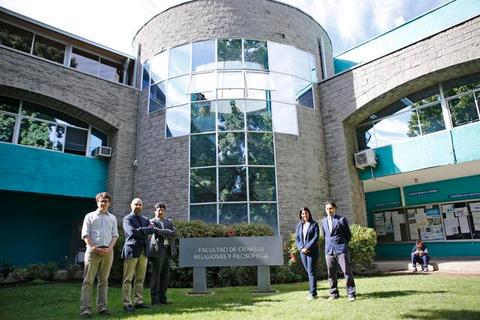 Grupo de personas posando frente a un edificio de la facultad de ciencias religiosas y filosóficas.