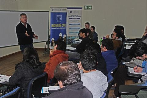 Un profesor da una clase en un aula con estudiantes atentos.