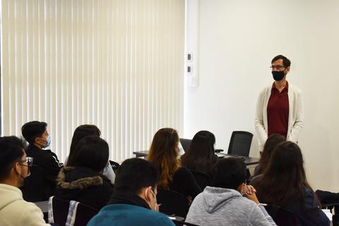 Un maestro enseña a un grupo de estudiantes en un aula.