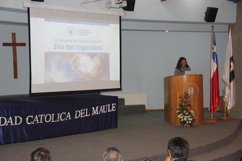 Una mujer habla en un evento relacionado con el Día del Ingeniero en un auditorio de la Universidad Católica del Maule.