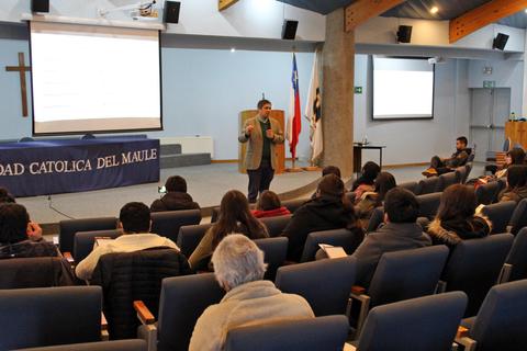 Una presentación en una sala con un orador frente a un público en una universidad.