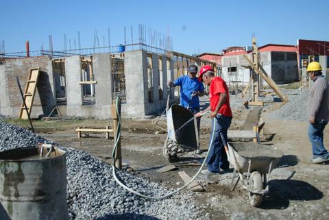 Trabajadores de la construcción están vertiendo concreto en un sitio de obras.