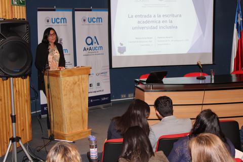 Una mujer presenta sobre escritura académica en un seminario universitario.