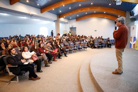 Un orador presenta ante un gran público en un auditorio.