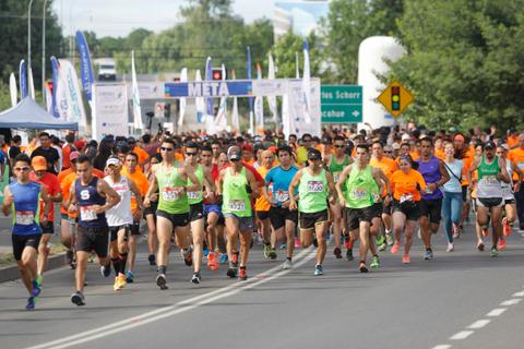 Un grupo de corredores participando en una carrera en la vía pública.