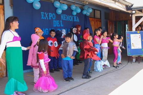 Un grupo de niños disfrazados en una presentación en el escenario.