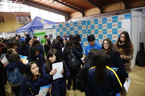 Un grupo de estudiantes interactuando en un evento educativo dentro de un gymnasium.