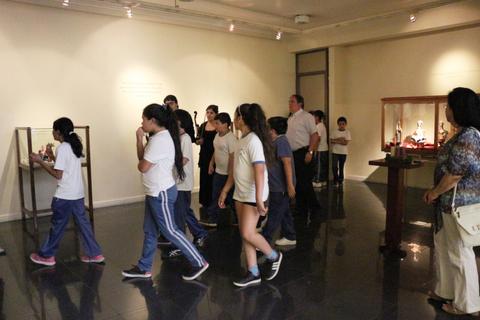 Un grupo de personas camina por una sala de museo observando las exhibiciones.