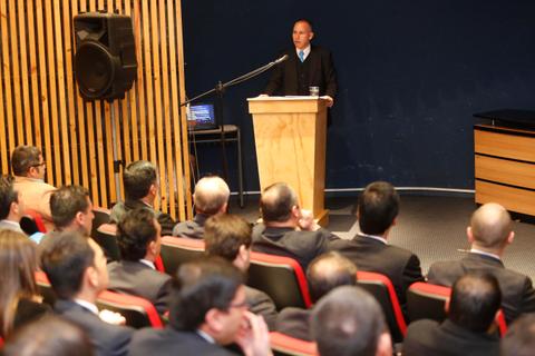 Un orador presenta ante una audiencia en un auditorio.