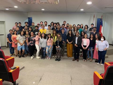 Un grupo grande de personas posando en un auditorio.
