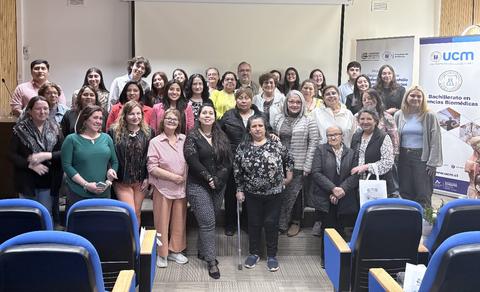 Un grupo entusiasta de personas posando juntas en un evento académico.