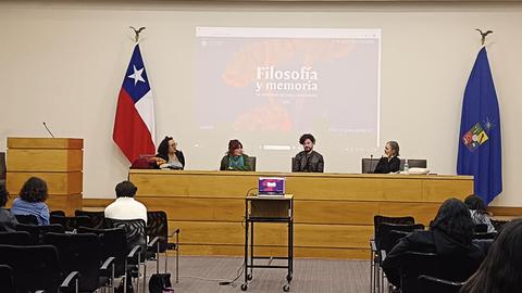 Una mesa de diálogo sobre filosofía y memoria con participantes en un auditorio.