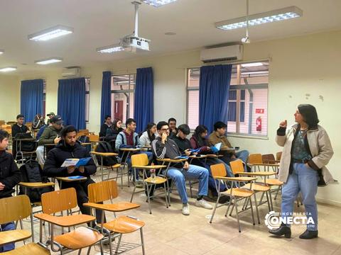 Una profe está dando una charla a estudiantes en un salón de clases.
