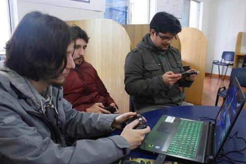 Tres personas están jugando videojuegos en un ambiente interior.