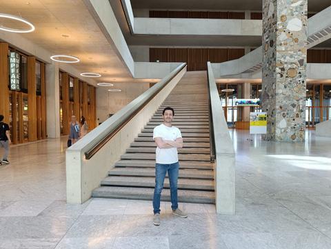 Un cabro parado frente a una escalera en un lugar moderno y luminoso.