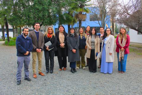 Un grupo de profesionales posando alegremente en un entorno al aire libre en Chile.