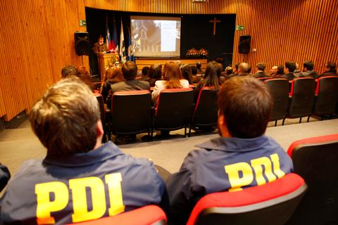 Una presentación en un auditorio con personas sentadas y un ponente frente a una pantalla.