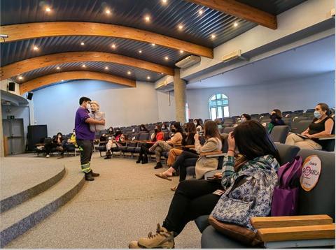 Un grupo de personas observa a un presentador en un auditorio durante una charla.