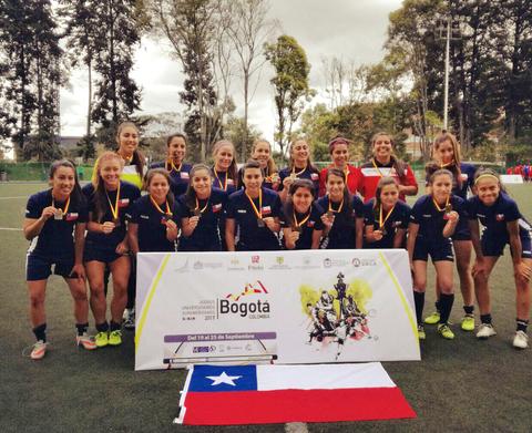 Un grupo de jugadoras de fútbol femenino posando con medallas en un torneo en Bogotá.