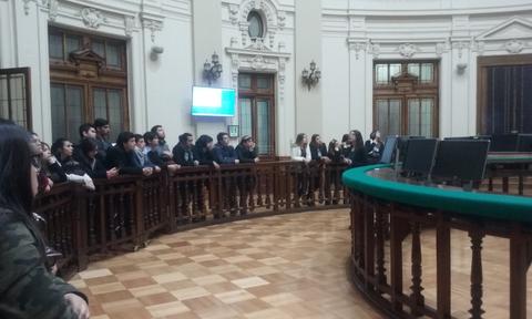 Un grupo de personas observa en un recinto con arquitectura clásica.